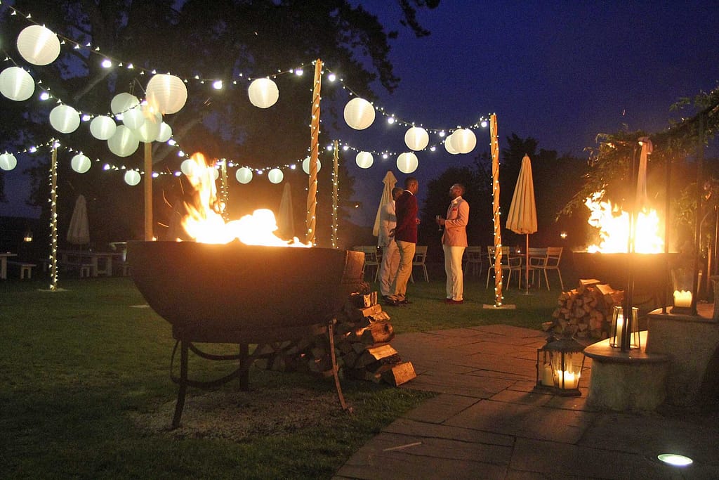 image of a lighting canopy with festoon lighting, fairy-lighting with fire-pits close by.