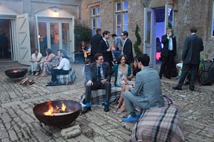 Image of people sitting around a fire pit at a wedding