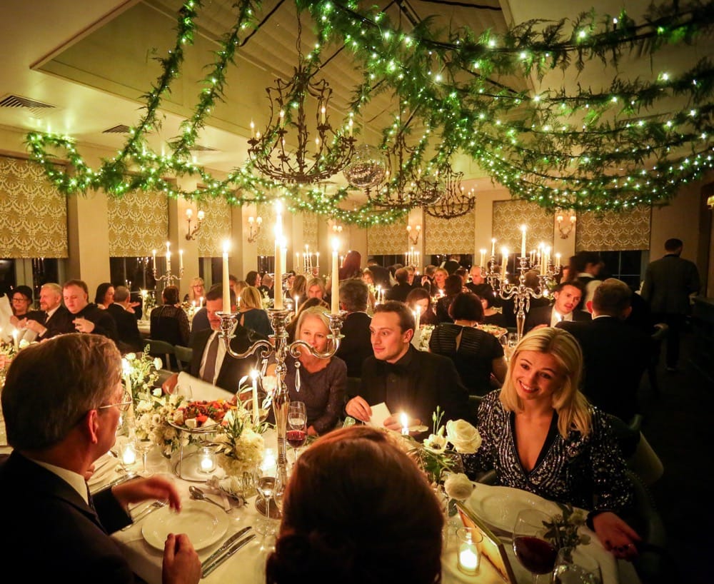 Image of fairy-light chains with foliage jnside a dining room with people eating