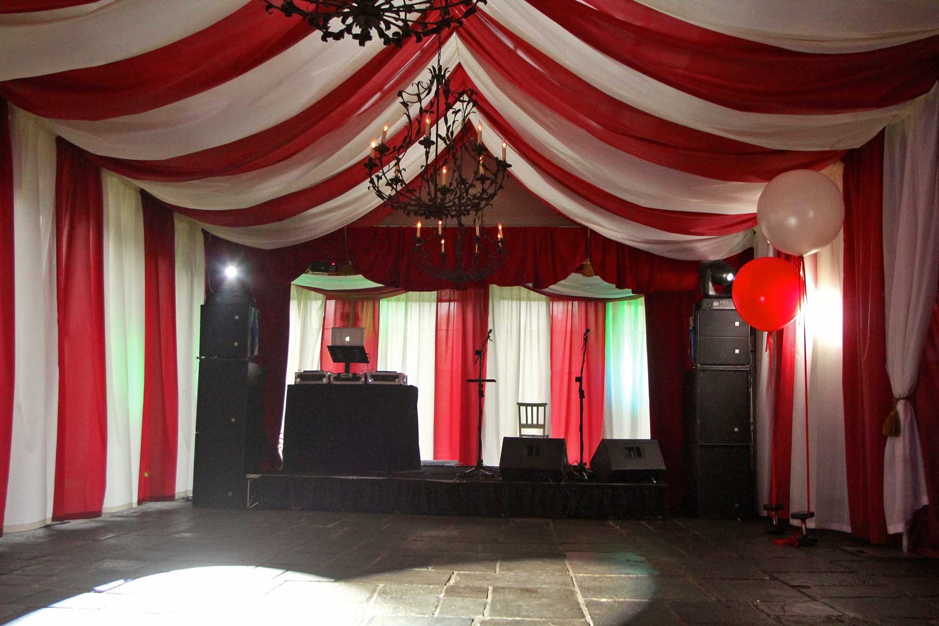 Image of a circus themed party with big top, stage and dj decks