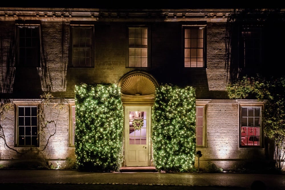 Image of the front of Babington House with the large bushes light.